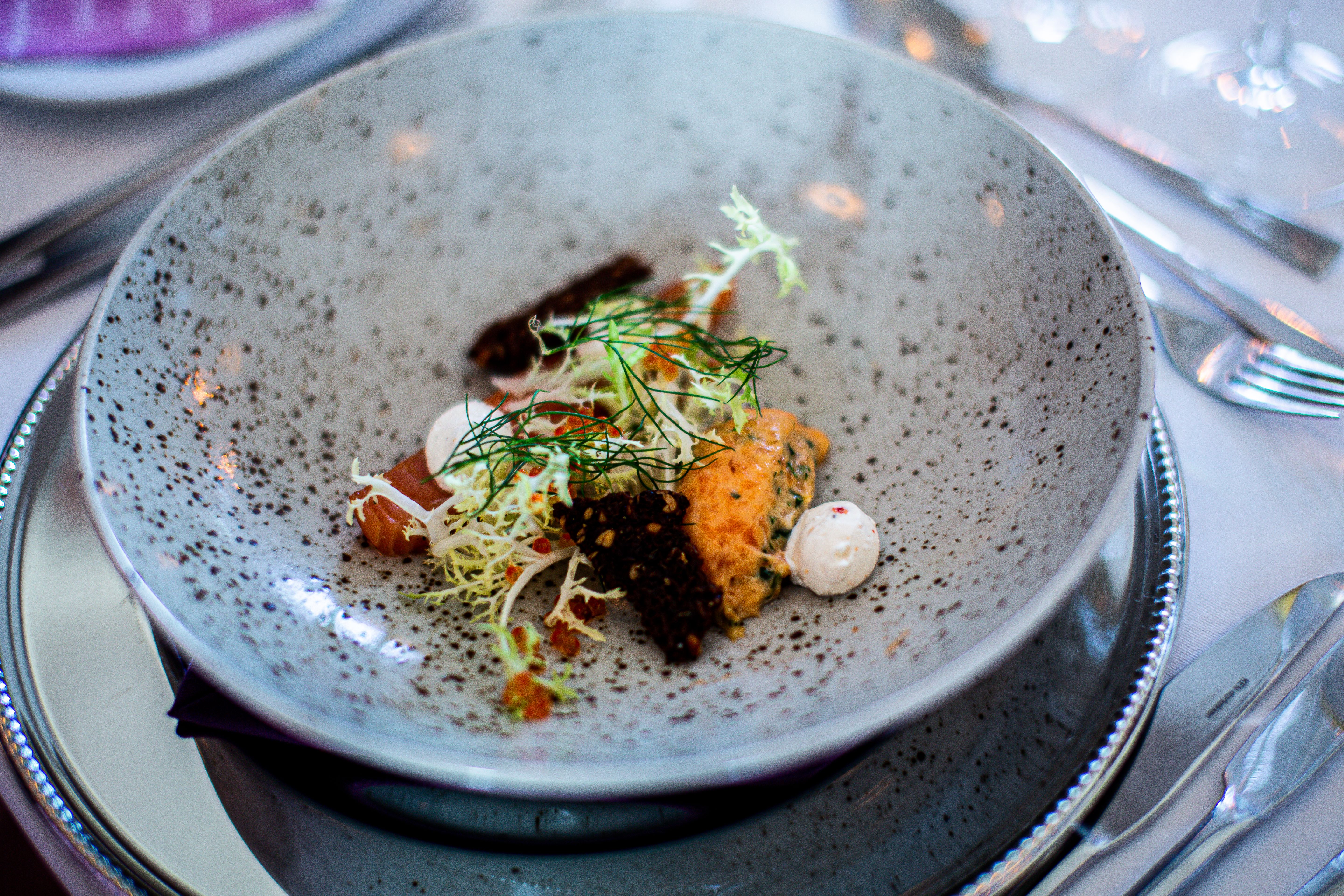 A refined gourmet dish presented with fresh herbs and careful restaurant plating.
