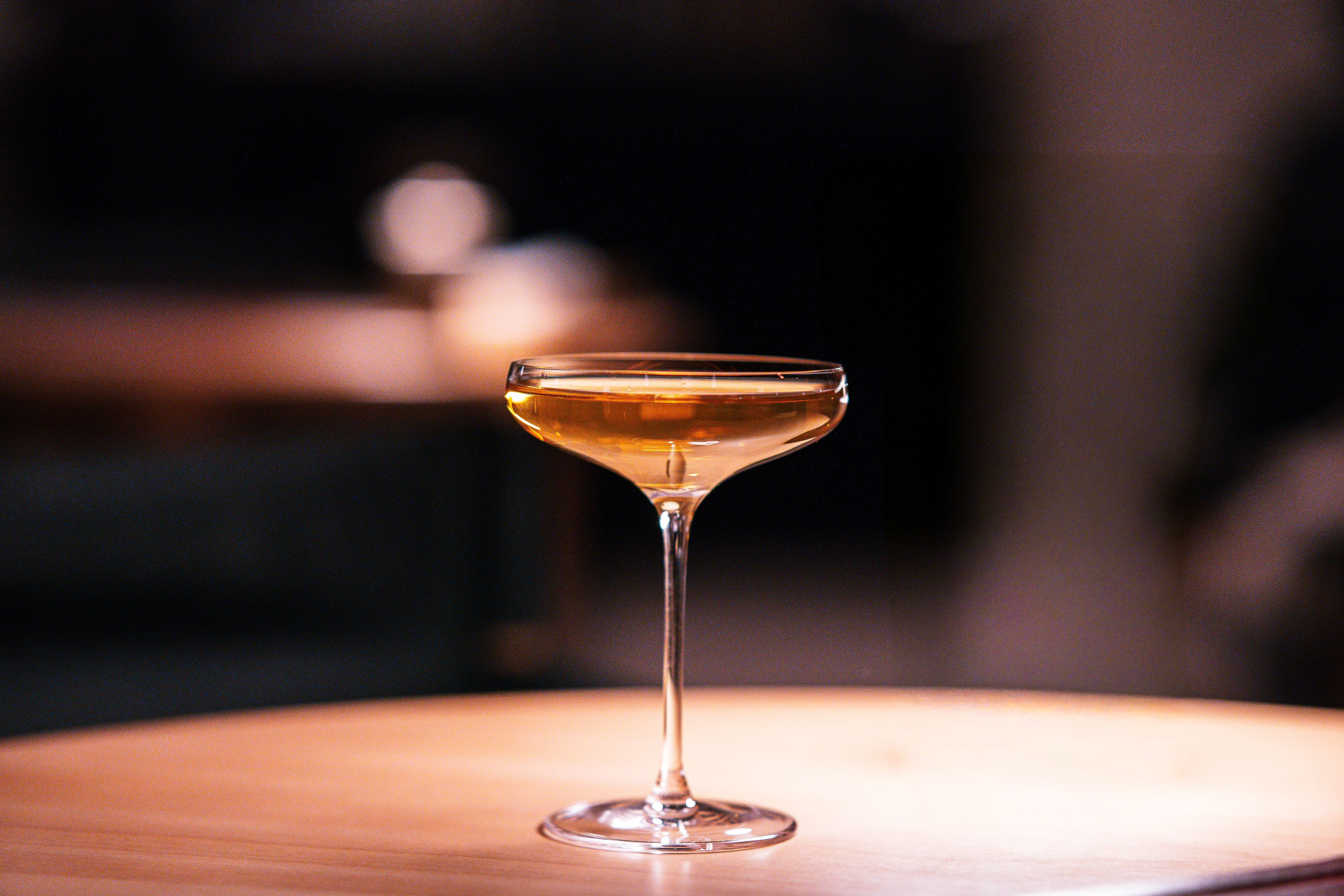 A carefully prepared cocktail in a sophisticated hotel bar with warm, atmospheric lighting.